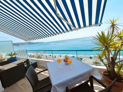a table with two glasses on it with a view of the beach at SEA VIEW TOP FLOOR - PROMENADE DES ANGLAIS in Nice