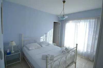 a bedroom with a white bed and a window at HELIANTHE - Superbe appartement avec terrasse vue mer et Château au Port de Nice in Nice
