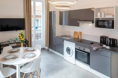 a kitchen and dining room with a white table and chairs at Lovely apartment with terrace Nice centre in Nice