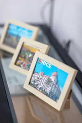 three framed photographs on a glass table at Lovely apartment with terrace Nice centre in Nice