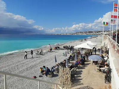 a crowd of people sitting on a beach at AM STUDIO NICE in Nice
