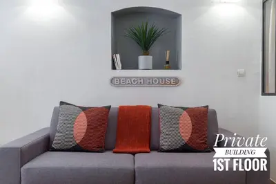 a gray couch with colorful pillows in a living room at PRIVATE BUILDING, 4 APTS, UNIQUE AT NICE- OLD TOWN in Nice