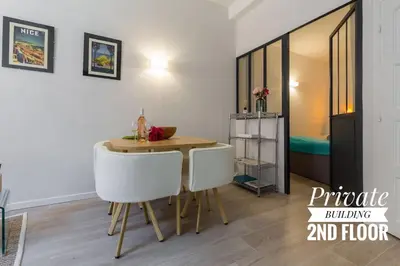 a dining room with a table and two white chairs at PRIVATE BUILDING, 4 APTS, UNIQUE AT NICE- OLD TOWN in Nice
