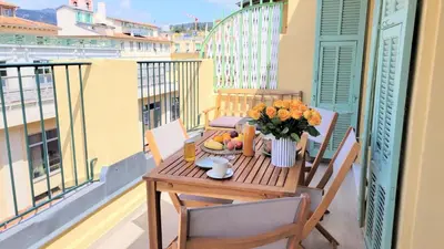 a table with a vase of flowers on a balcony at Ze Perfect Place - Opera Nice - Appartement 2 Chb - AC - Terrasse in Nice