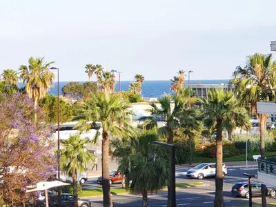 a view of a parking lot with palm trees at Beautiful T1 with sea view in Nice