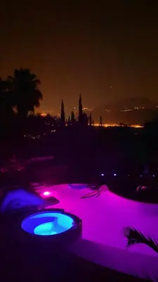 a swimming pool lit up with purple lights at night at Villa Canarias in Saint-Jeannet