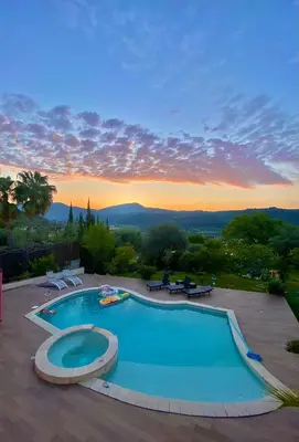 a swimming pool with a sunset in the background at Villa Canarias in Saint-Jeannet