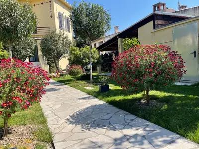 a walkway in front of a house with pink flowers at Les palmiers in Nice