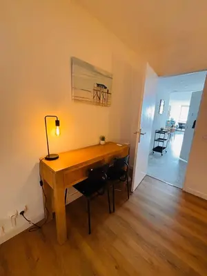 a desk with a lamp and chairs in a room at Plage Landsberg - Saint-Laurent-du-Var in Saint-Laurent-du-Var
