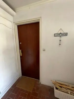 a hallway with a brown door and a sign on the wall at Plage Landsberg - Saint-Laurent-du-Var in Saint-Laurent-du-Var