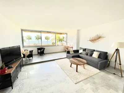 a living room with a couch and a tv at Plage Landsberg - Saint-Laurent-du-Var in Saint-Laurent-du-Var