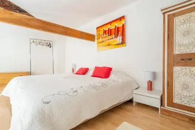 a bedroom with a white bed with red pillows at Stunning Duplex place Masséna 2 mins walk from beaches in Nice