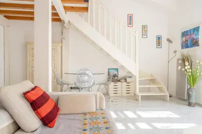 a living room with a couch and a staircase at Stunning Duplex place Masséna 2 mins walk from beaches in Nice