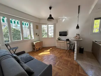 a living room with a couch and a television at Le 29 Promenade des Anglais - Golden Square in Nice