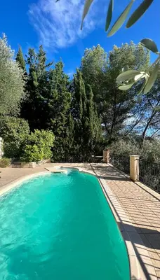 a patio with couches and tables and an umbrella at Entre Nice et Monaco grande Villa avec piscine privée 12 personnes in Drap