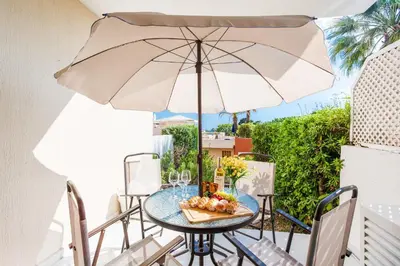 a table and chairs with an umbrella on a balcony at L'ANGE GARDIEN III AP4293 By Riviera Holiday Homes in Villefranche-sur-Mer