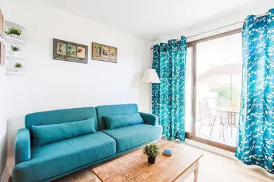 a blue couch in a living room with a window at L'ANGE GARDIEN III AP4293 By Riviera Holiday Homes in Villefranche-sur-Mer