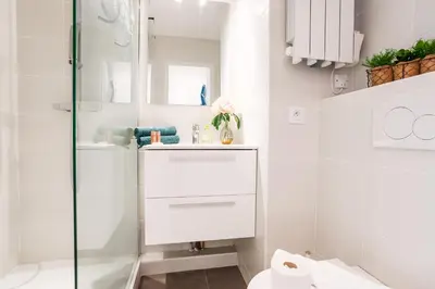 a white bathroom with a sink and a toilet at L'ANGE GARDIEN III AP4293 By Riviera Holiday Homes in Villefranche-sur-Mer