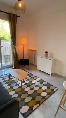 a living room with a couch and a table and a rug at Appartement entier. Nice Riquier in Nice