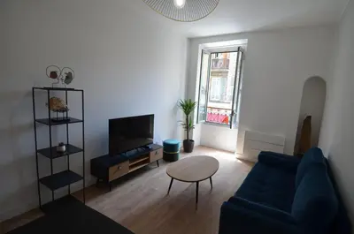 a living room with a blue couch and a table at NAPOLEON - Superbe appartement 2 chambres au cœur du Port de Nice in Nice