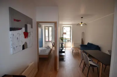 a living room with a table and a dining room at NAPOLEON - Superbe appartement 2 chambres au cœur du Port de Nice in Nice