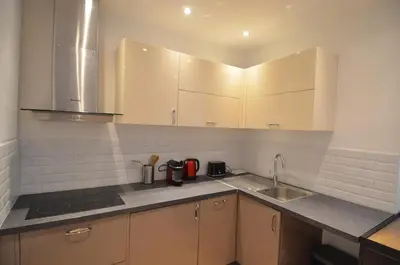 a kitchen with white cabinets and a sink at NAPOLEON - Superbe appartement 2 chambres au cœur du Port de Nice in Nice