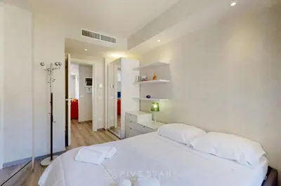 a bedroom with a large white bed with white pillows at Suite Horizon FSHH in Beaulieu-sur-Mer