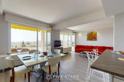 a dining room and living room with a table and chairs at Suite Horizon FSHH in Beaulieu-sur-Mer