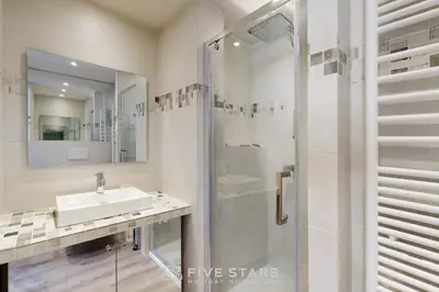 a white bathroom with a sink and a shower at Suite Horizon FSHH in Beaulieu-sur-Mer