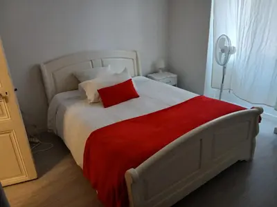 a bedroom with a bed with a red pillow on it at Bel appartement pour vos séjours sur la côte in Nice