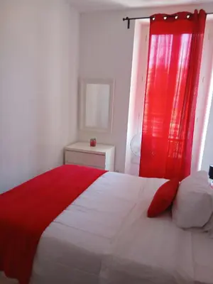 a bedroom with a bed with a red curtain at Bel appartement pour vos séjours sur la côte in Nice