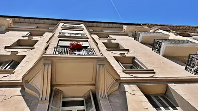 a building with a flower pot on a balcony at LE RIQUIER - Port Lympia à 10 mins à pied in Nice