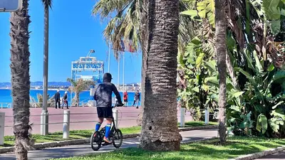 a man riding a bike on the beach at LE RIQUIER - Port Lympia à 10 mins à pied in Nice
