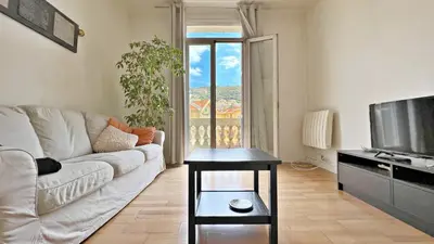 a living room with a couch and a tv at LE RIQUIER - Port Lympia à 10 mins à pied in Nice