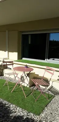 a picnic table and chairs sitting on the grass at Studio - 1 minute de la plage et de la Promenade des Anglais in Nice