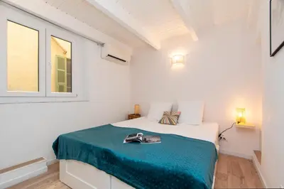 a white bedroom with a white bed and a window at Maison Bianchi - Prefecture - Old Town in Nice