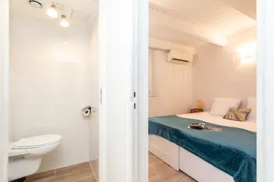 a small white bedroom with a bed and a toilet at Maison Bianchi - Prefecture - Old Town in Nice