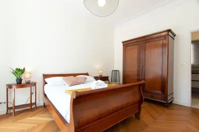 a bedroom with a bed and a wooden cabinet at Maison Bianchi - Victor Hugo in Nice