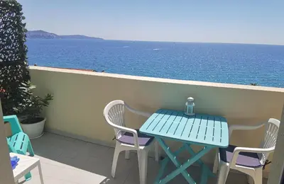 a table and chairs on a balcony overlooking the ocean at Studio Le Grand Bleu Fshh in Nice
