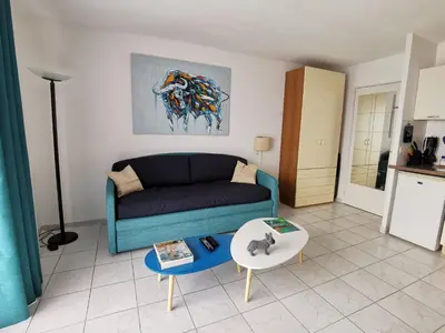 a living room with a couch and a table at Studio Le Grand Bleu Fshh in Nice