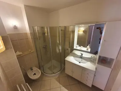 a living room with a bed and a dresser and a window at Appartement F3 traversant avec 2 terrasses et parking in Cagnes-sur-Mer