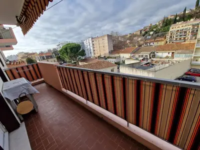 an empty hallway of a building with a table at Appartement F3 traversant avec 2 terrasses et parking in Cagnes-sur-Mer