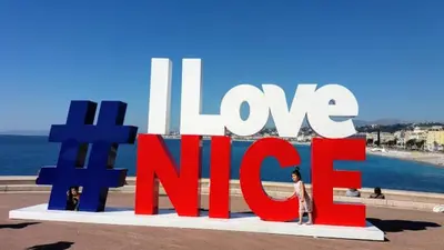 a woman standing in front of a large sign with the word lovemite at 