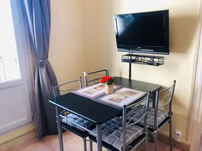a table with two chairs and a television on a wall at 