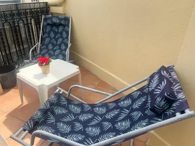 a chair sitting next to a table with a plant at 