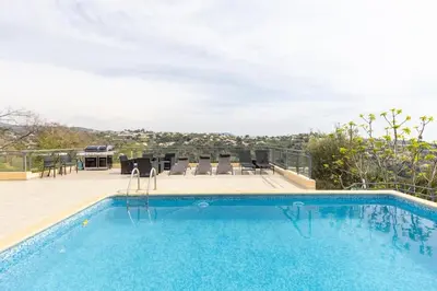 a swimming pool with chairs and a table on a patio at Spacieuse Villa Niçoise au calme avec piscine in Nice