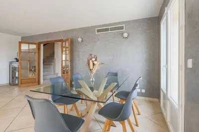 a dining room with a glass table and chairs at Spacieuse Villa Niçoise au calme avec piscine in Nice