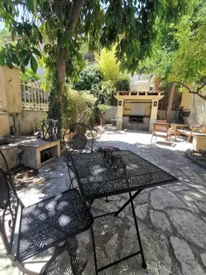 a patio with a table and chairs under a tree at Appartement, 3 pièces, Villa Monte Europa in Nice