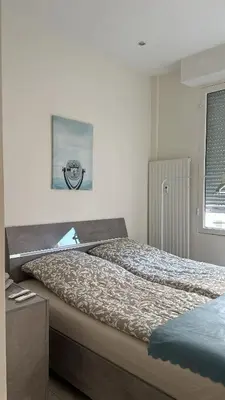 a bedroom with a bed and a picture on the wall at Новая 3-комнатная квартира на 2й линии от моря. in Nice