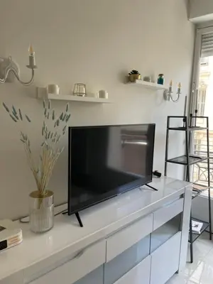 a flat screen tv sitting on top of a white entertainment center at Новая 3-комнатная квартира на 2й линии от моря. in Nice